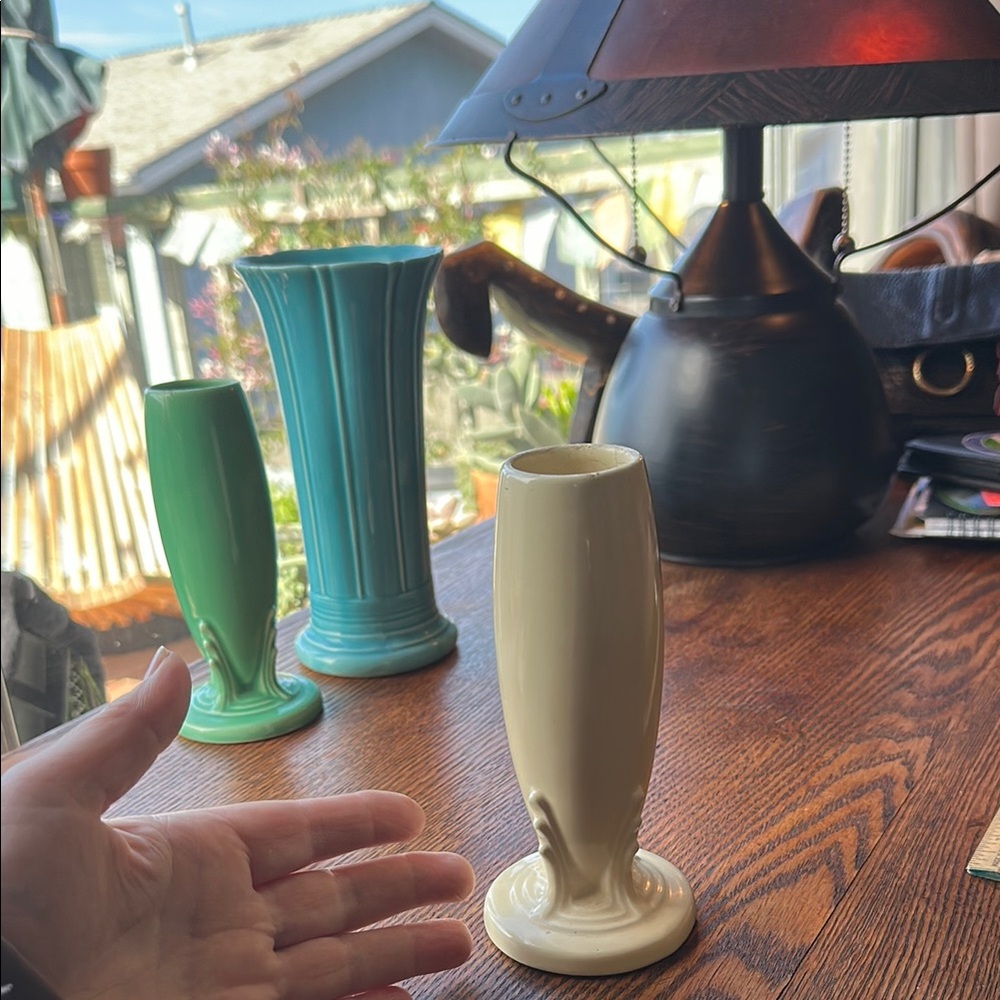 Vintage Fiestaware 6” tall bud vase. Shows signs of ware. Chip on bottom. Cream